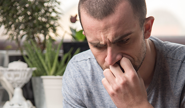 Man looking worriedly at his phone, trying to figure out finances.